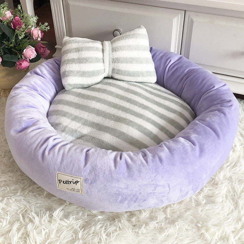 Cama acolchada para perro y gato con almohada en forma de lazo, color morado, vista frontal completa
